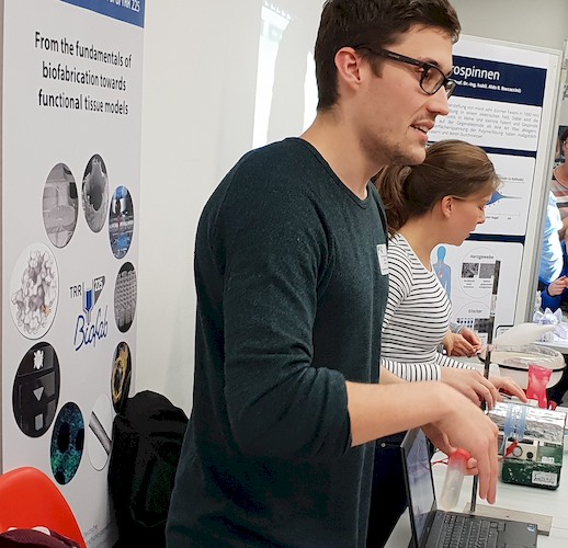 Thomas Kreller erklärt einem interessierten Besucher das Thema 3D Biofabrikation.