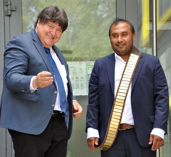 Prof. Boccaccini überreicht den Ledergurt mit den Namen aller bisherigen Doktoranden an Qaisar Nawaz